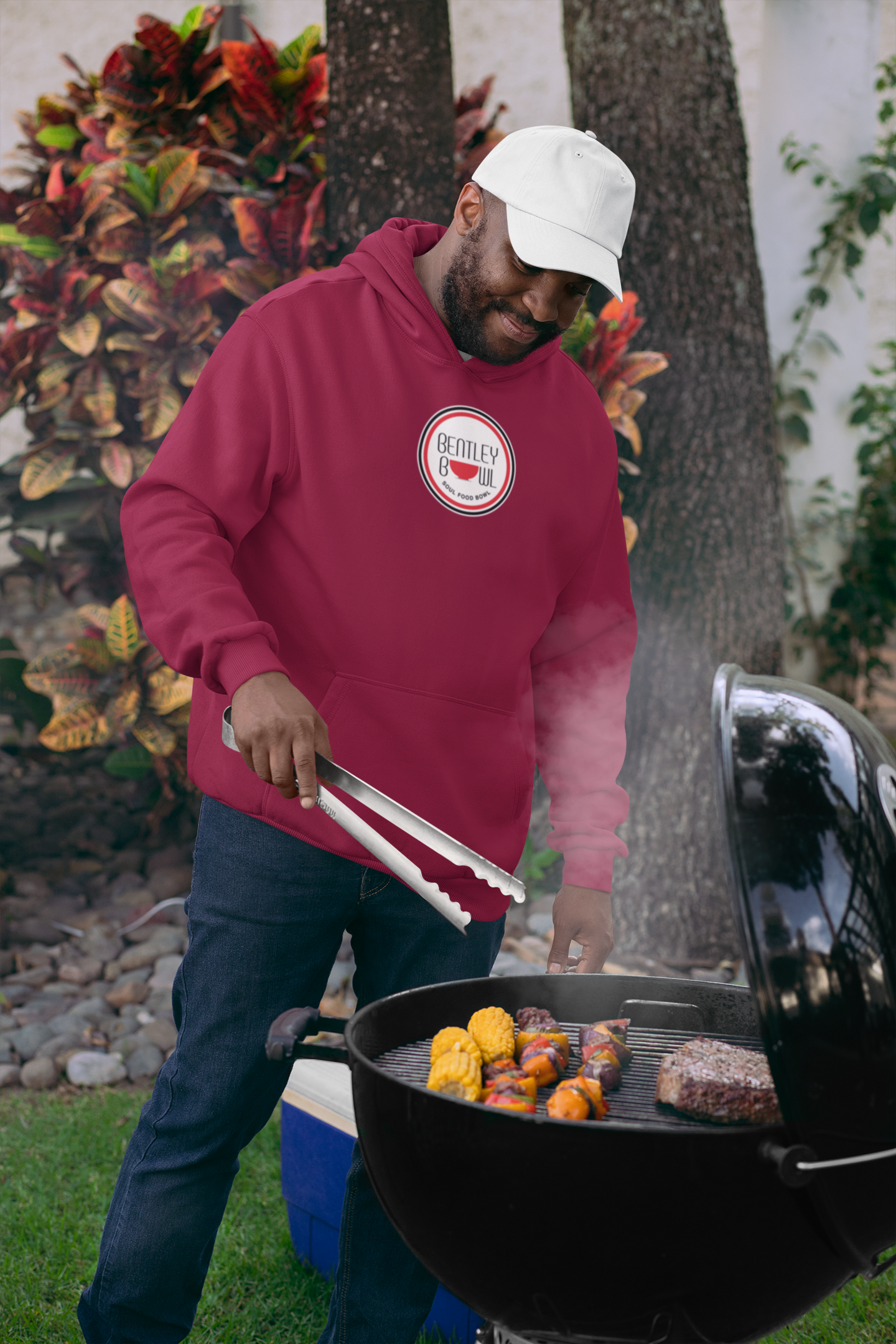 files/pullover-hoodie-mockup-of-a-man-wearing-a-dad-hat-grilling-food-29712.png