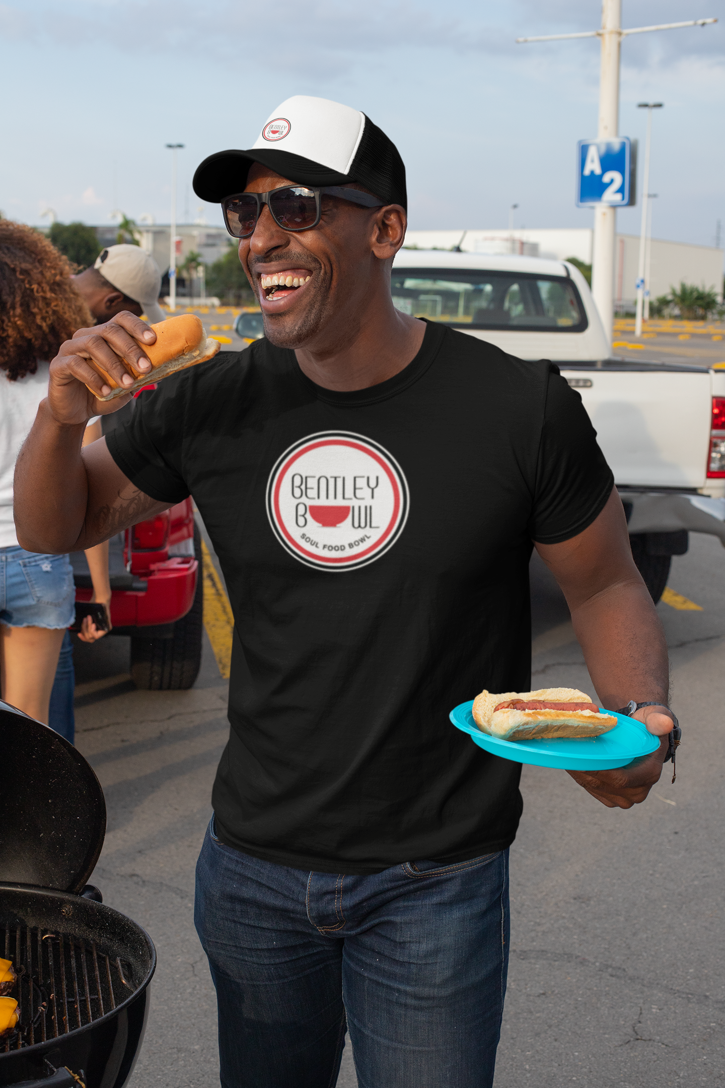 files/t-shirt-mockup-of-a-man-with-a-trucker-hat-eating-at-a-tailgate-party-29893.png